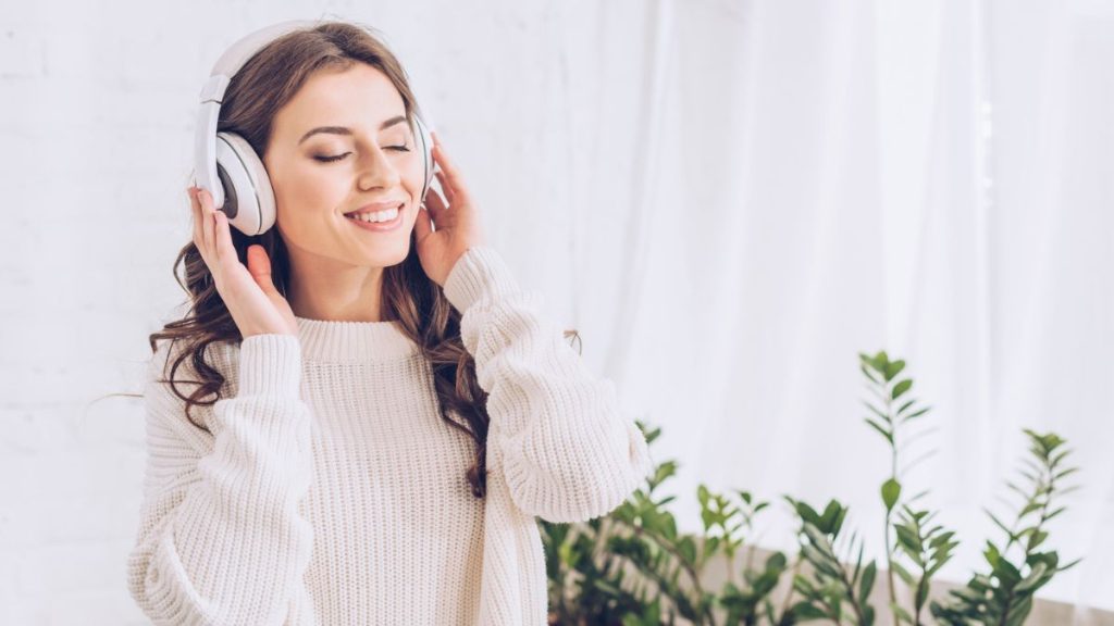 Woman Listening To Music Using Headphone Smiling