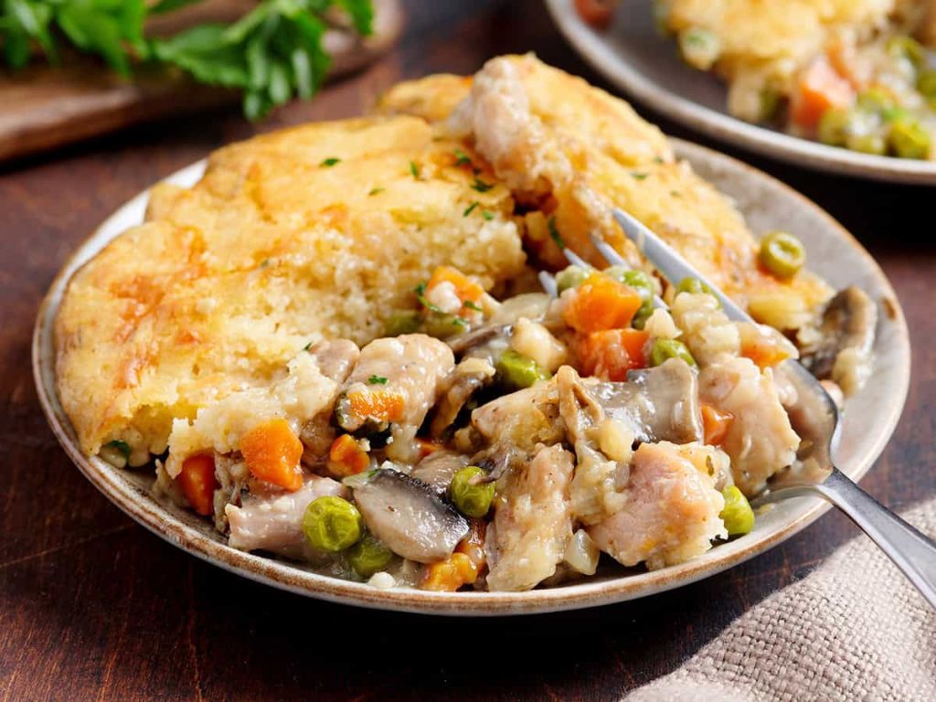 Side view of chicken cobbler on a plate with a fork.
