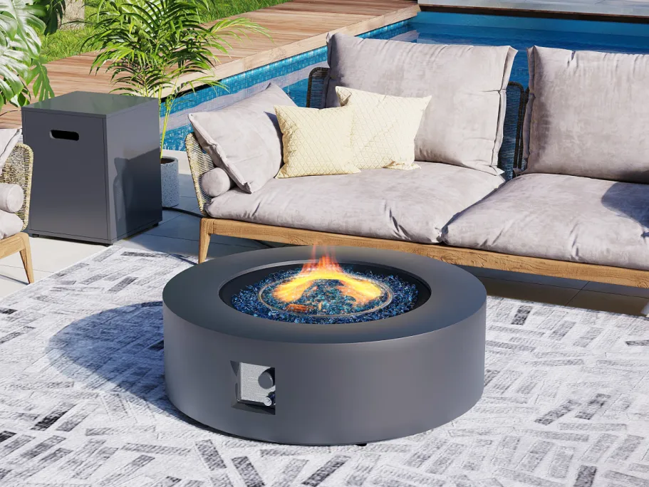 Lowe’s Daily Deals | Up to 50% Off Craftsman, Fire Pit Tables, & More! A round fire pit table in front of a sofa outside.