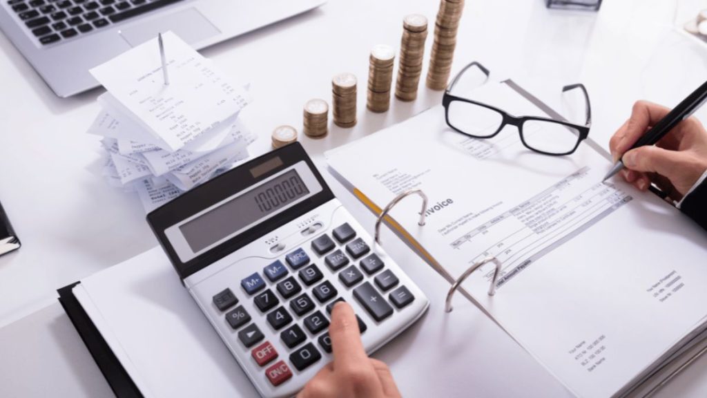 A Guide to Tax-Efficient Investing Man calculating his tax MSN calculator glasses papers
