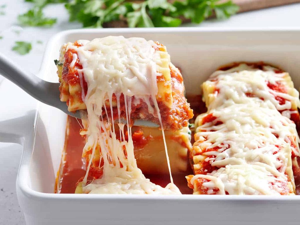 Lasagna Roll Ups – Budget Bytes lasagna roll up pulled out of casserole dish on a spatula
