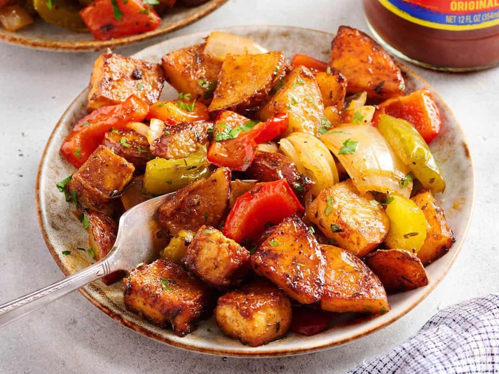 A plate of Sheet Pan Cajun Tofu and Vegetables with a fork.