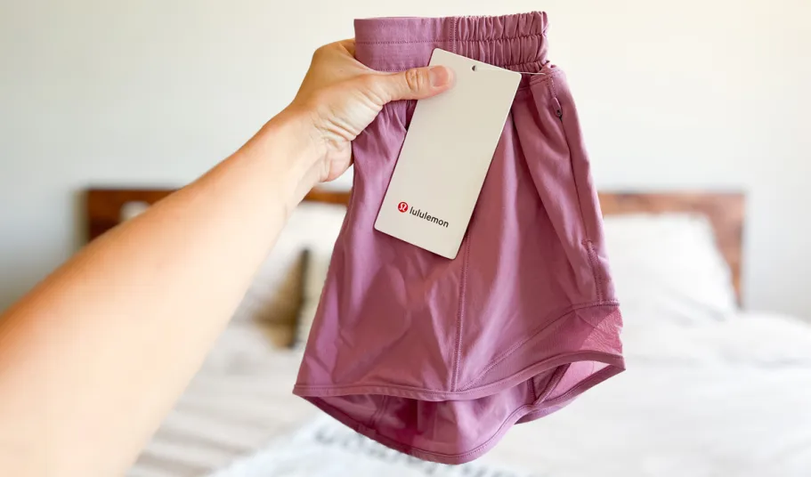 *HOT* Up to 70% Off lululemon Women’s Shorts hand holding up a pair of pink lululemon shorts
