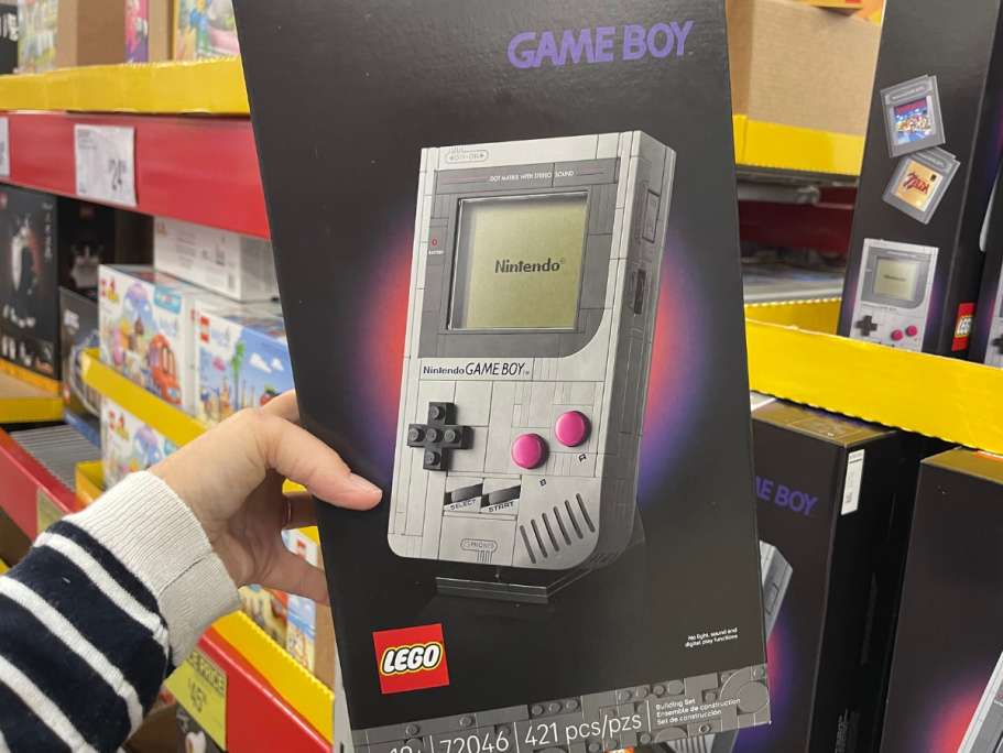 RARE $10 Off $50 Kohl’s Toys Coupon | Includes LEGO Sets, tonies, & More hand holding a box of a LEGO Nintendo Gameboy set