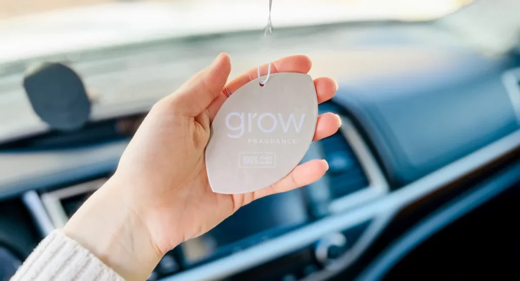 Safe & Non Toxic Air Freshener & Perfume Products hand holding grow car natural air freshener hanging from mirror