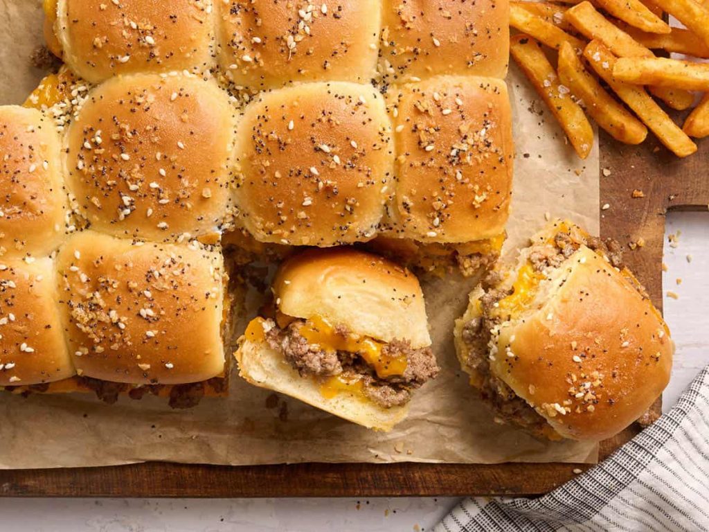 Sliders (Go-To Mini Burgers for Parties) Overhead view of sliders on parchment paper.