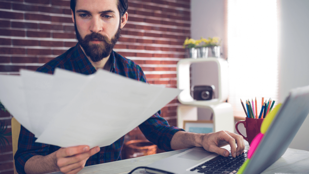Businessman with laptop and reading documents