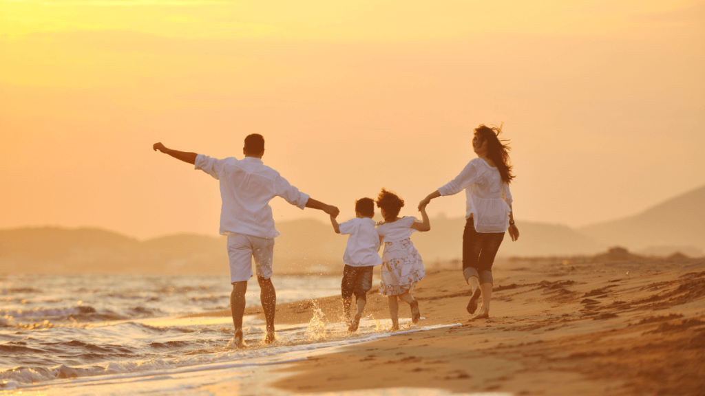 Happy young family have fun on beach at sunset