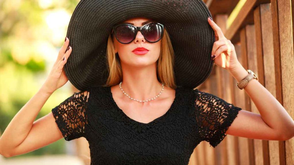Breaking Free of These 14 Boomer Trends That Are Finally History Woman using shades and big hat black MSN