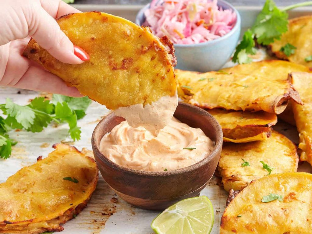 crispy baked taco dipped in sauce