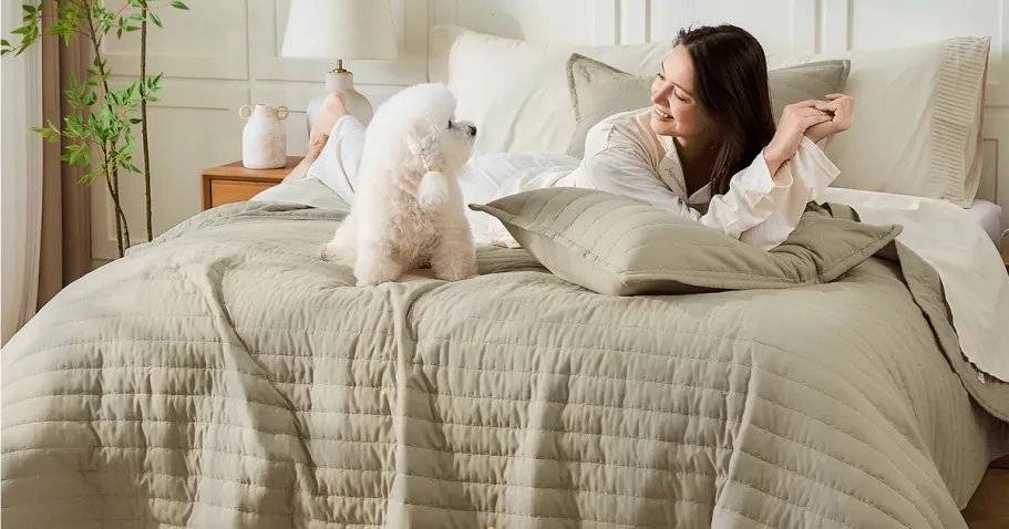 Up to 55% Off Litanika Quilt Sets + Free Shipping | Styles from $30 Shipped (Reg. $70) woman and dog laying on tan quilted blanket