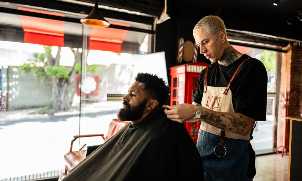 Barber Business Insurance: Best Carriers and Coverage Barber putting a cape on the customer at a barber shop