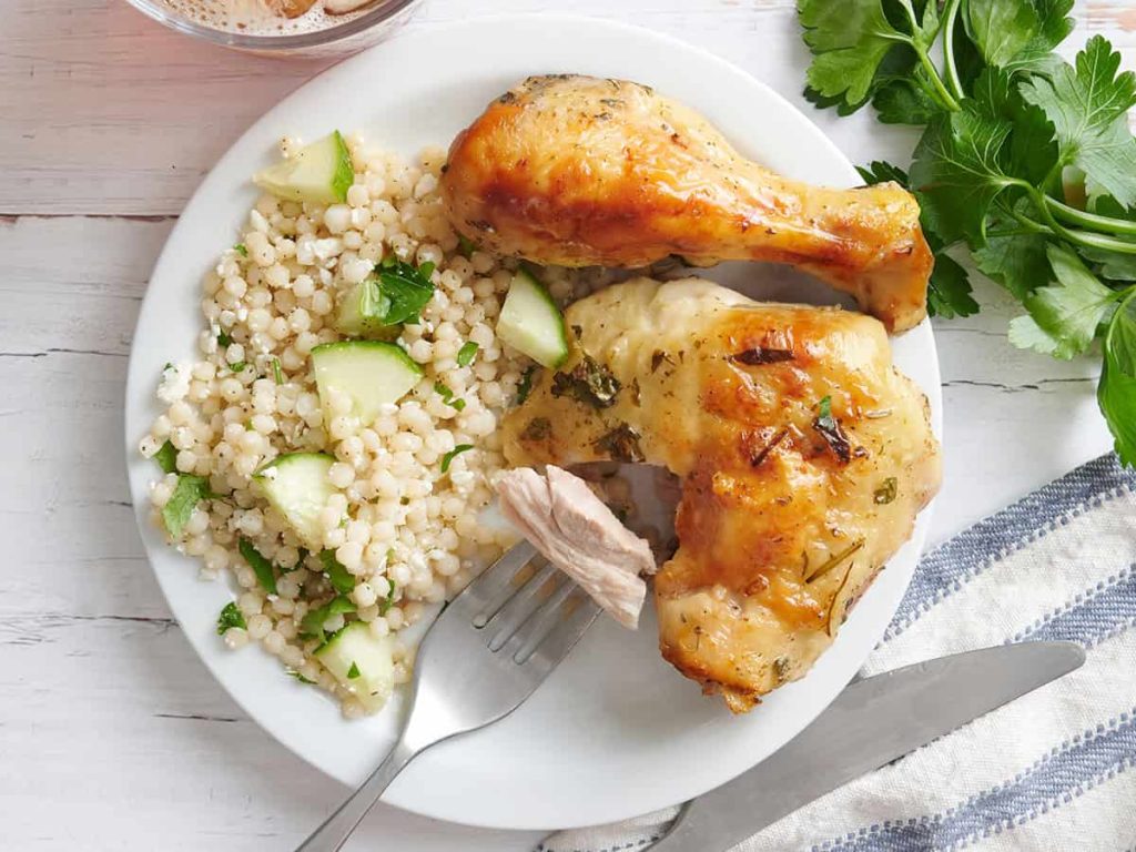 Greek Chicken – Budget Bytes Overhead view of a plate of greek marinated chicken with couscous and a fork with some chicken on.
