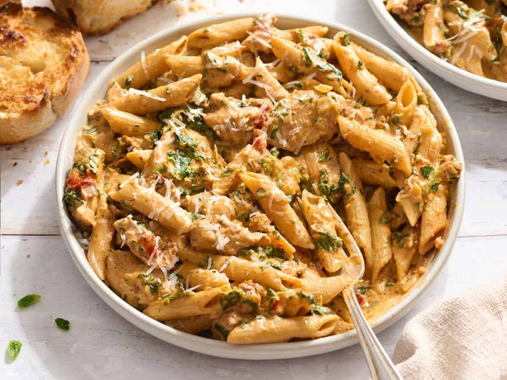 Marry Me Chicken Pasta – Budget Bytes Overhead side view of marry me chicken pasta in a bowl with a fork.