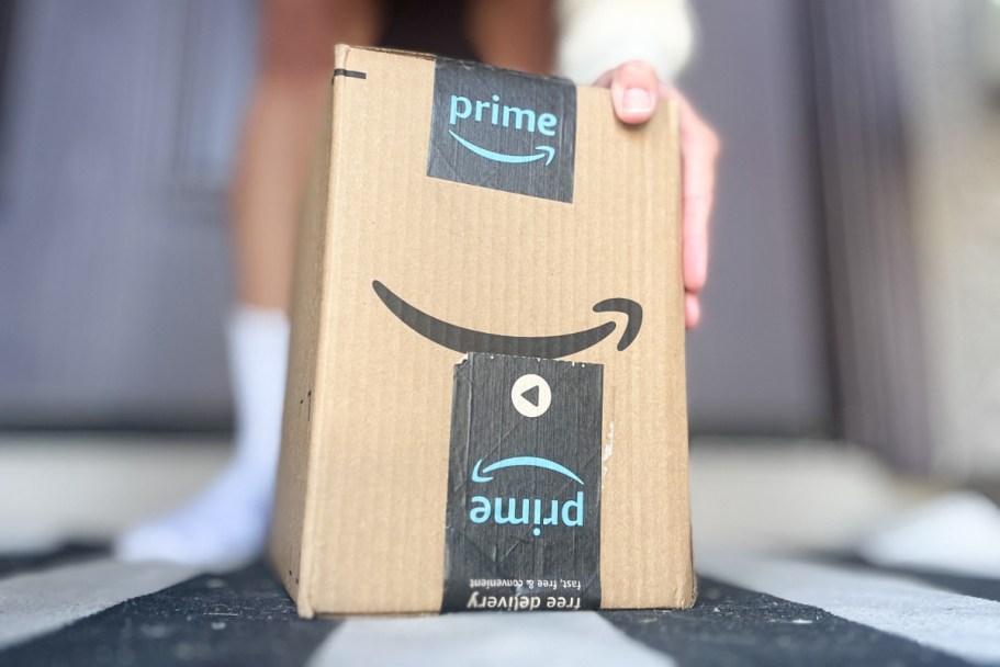 Save on Amazon Fashion w/ the Best Promo Codes Available Now! A hand holding up an Amazon box.