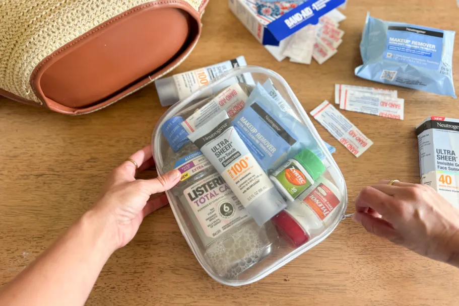 Score Up to $100 Walmart Cash on Summer Essentials hand grabbing clear pouch with hygiene, beauty, and more products
