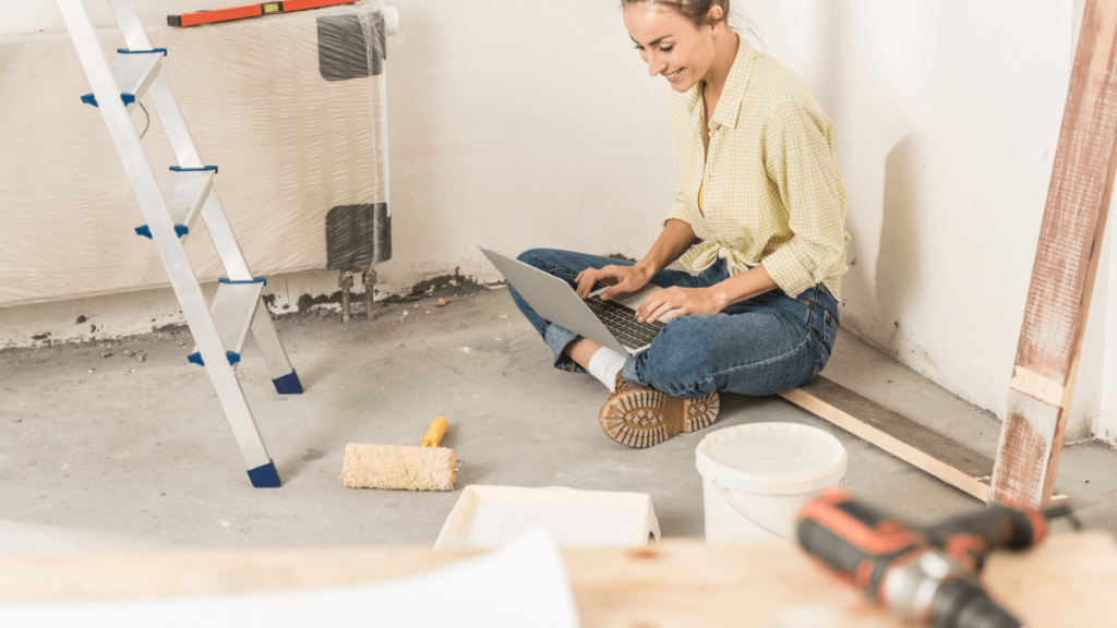 What are the Most Common Home Repair Costs? Woman using laptop while sitting on floor at new house