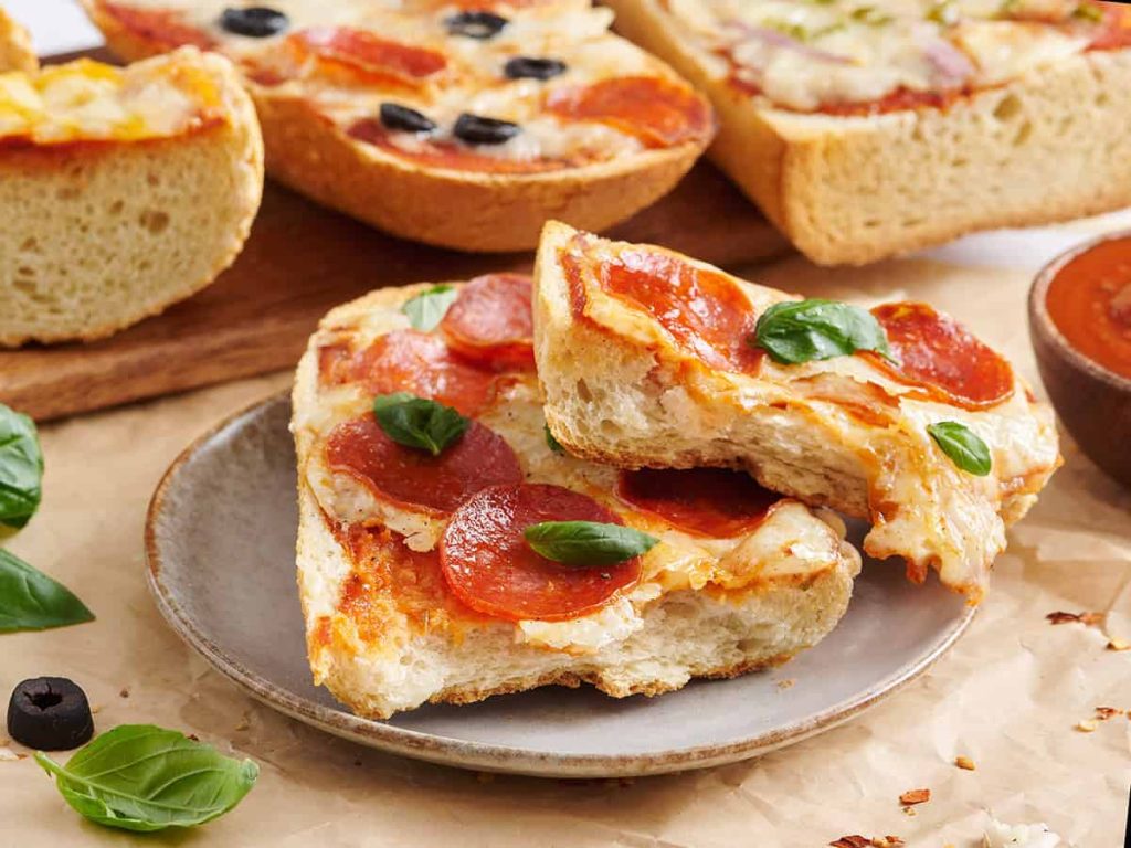 French Bread Pizza Recipe – Fun, Fast & Easy! Side view of a pepperoni French bread pizza sliced in half.